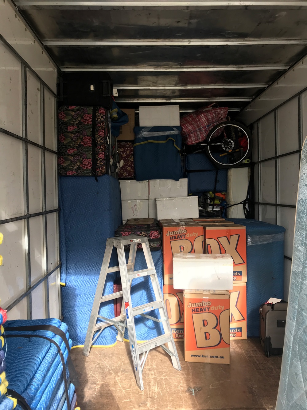 Phil’s Furniture Freighters removalist truck loaded with furniture, boxes, and protective blankets for interstate delivery between Melbourne, Canberra, and Sydney.