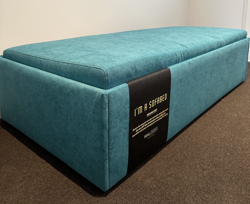 Close view of the Zara Ottoman Bed upholstery seam, corner and product label in Albert Park.