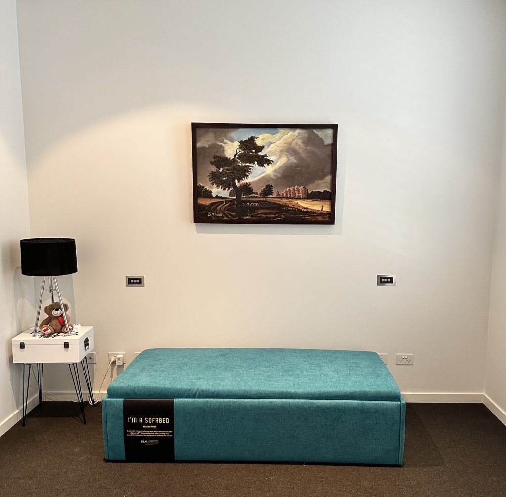 Front view of the teal Zara Queen Ottoman Bed in Albert Park, with its product label attached.