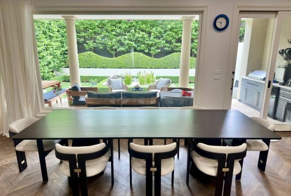 Christian Cole solid timber dining table centred in front of a large window in a Canterbury, Victoria dining room.