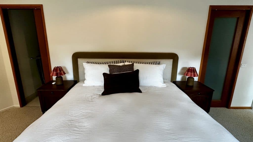 Pair of bedside tables with walnut stain finish positioned either side of the bed in Barwon Heads.