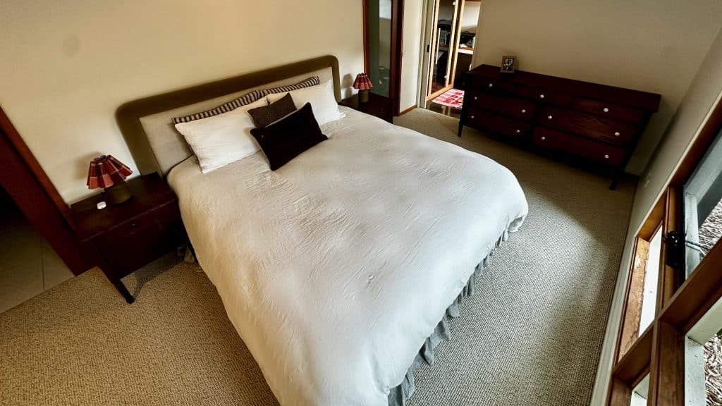 Wide bedroom view showing dresser placement and overall room setup.