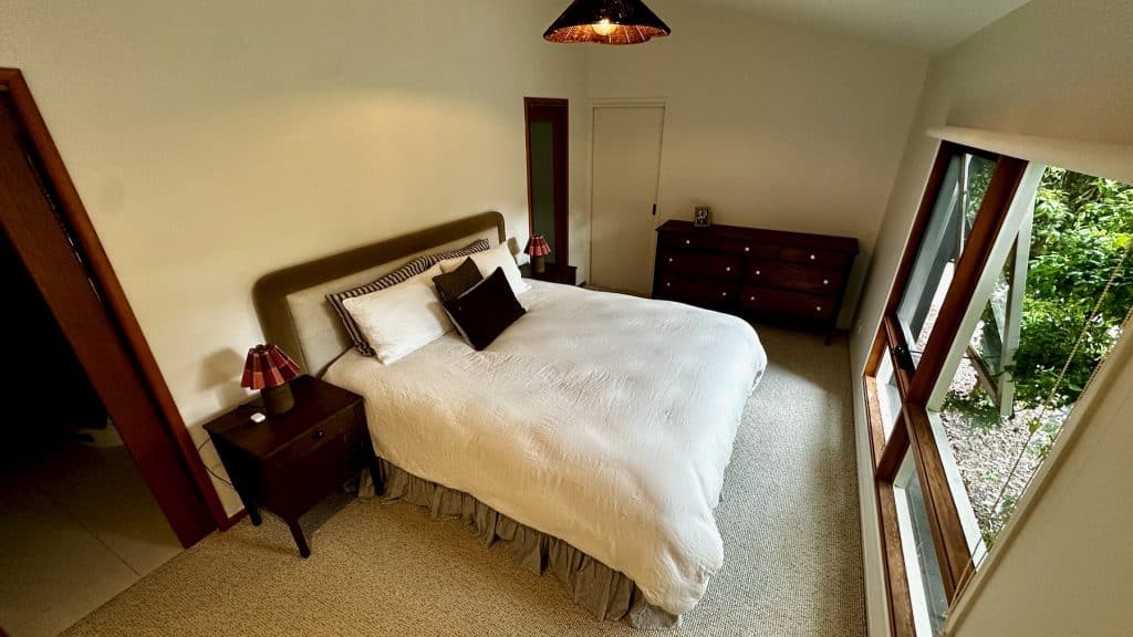 Wide view of the main bedroom in Barwon Heads with the Upcycled Wood Design dresser and bedside tables.