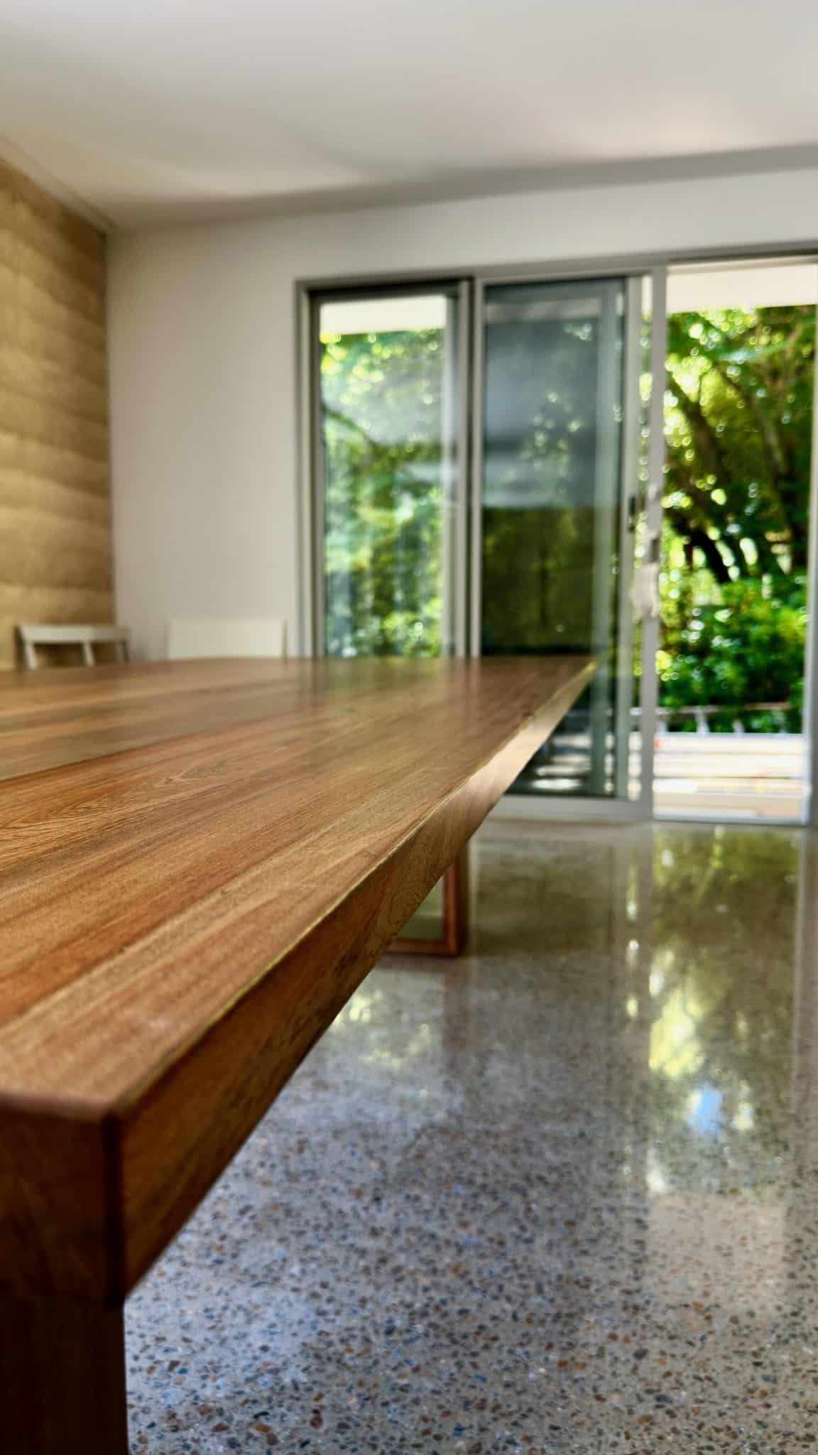 Side view along the timber dining table top in the finished room.