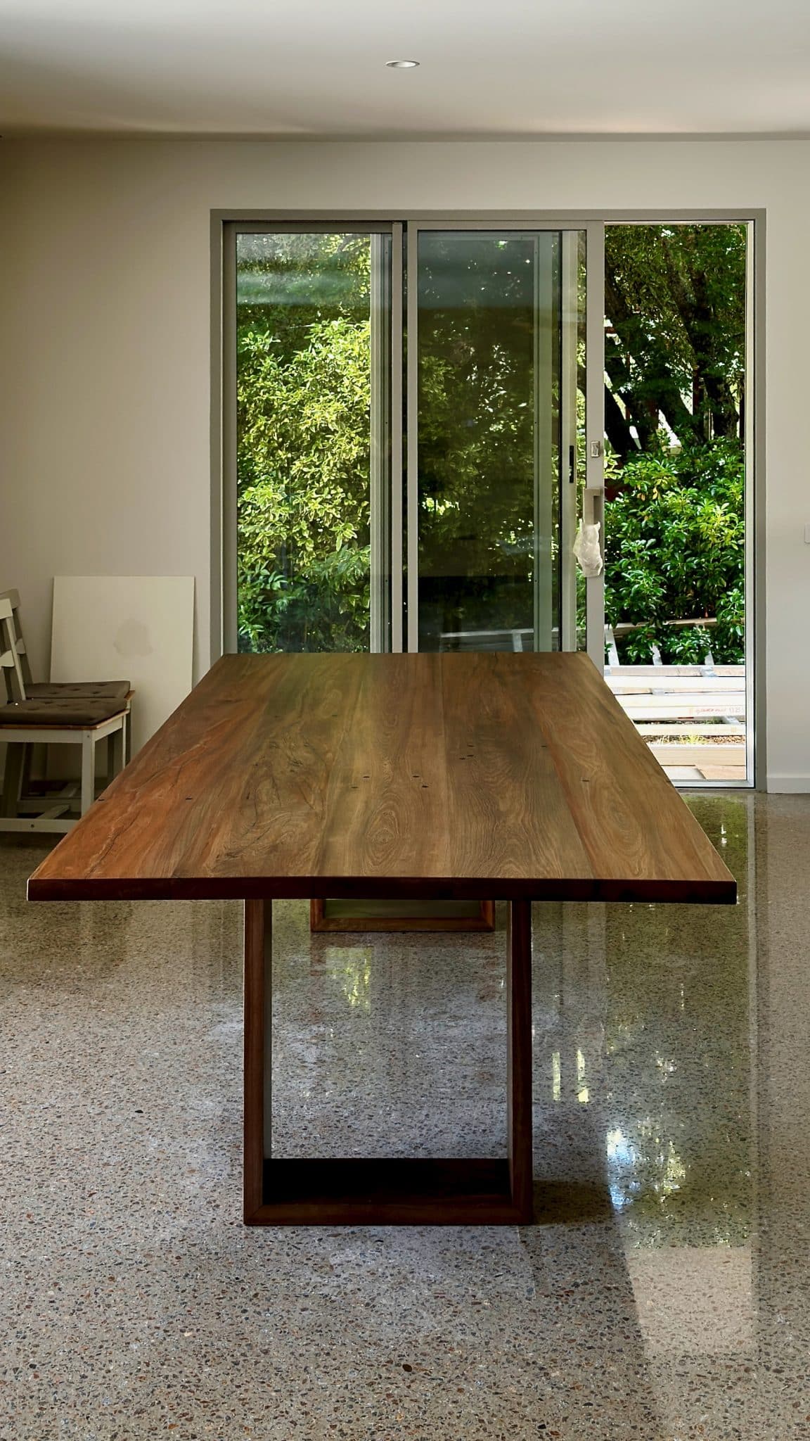 End view of the Christian Cole dining table centred in the room with natural light.