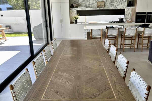 Lengthwise view of a Christian Cole dining table with chairs