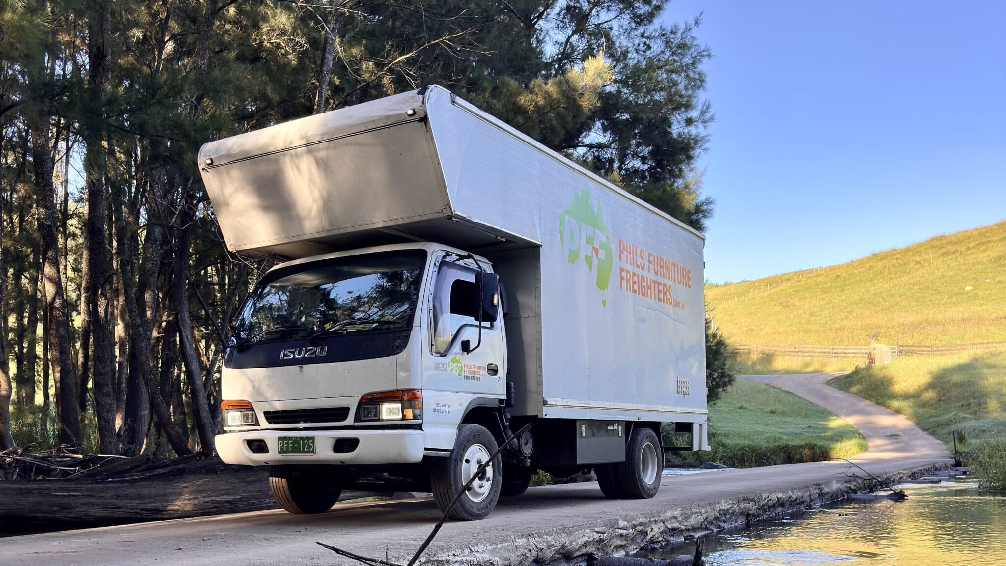 Phil’s Furniture Freighters truck delivering furniture for Bailey & Co Antiques in Megalong Valley NSW on a scenic rural road.