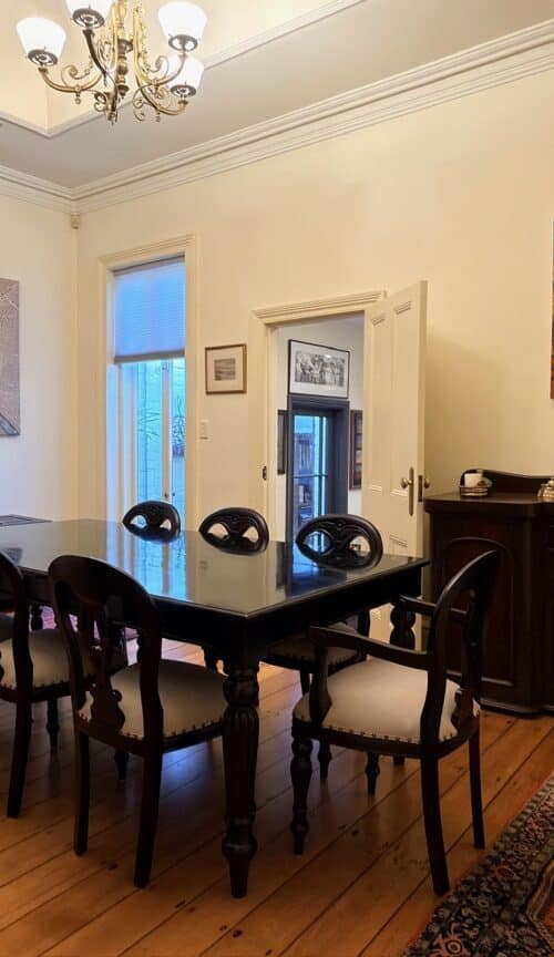 Dark timber dining table and eight chairs delivered and assembled in a McMahons Point home