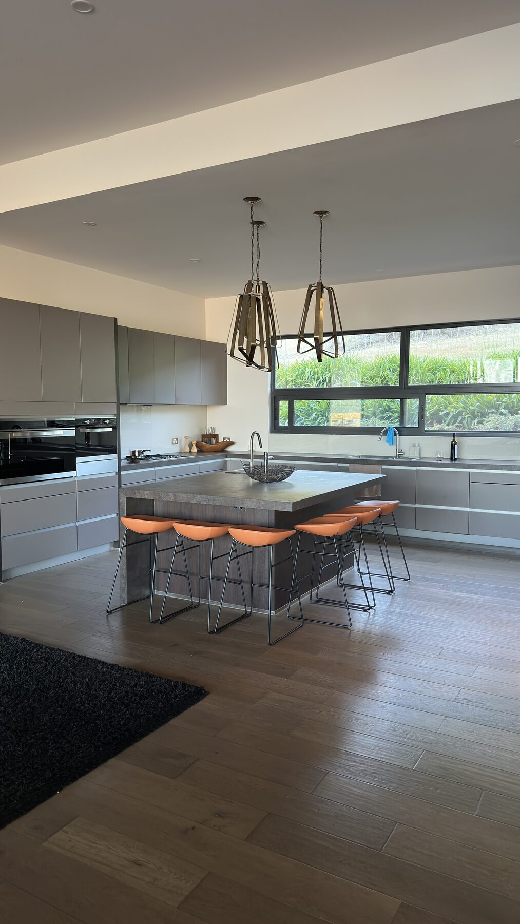 Tan bar stools arranged around a large grey kitchen island in Bonnie Doon