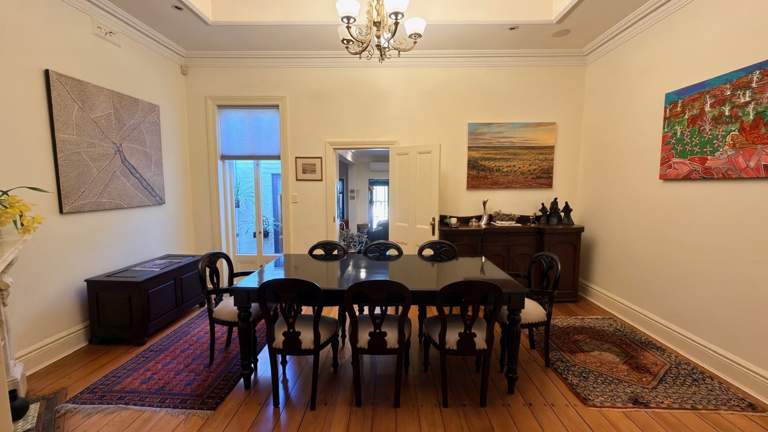Dark timber dining setting carefully placed between rugs in a period dining room