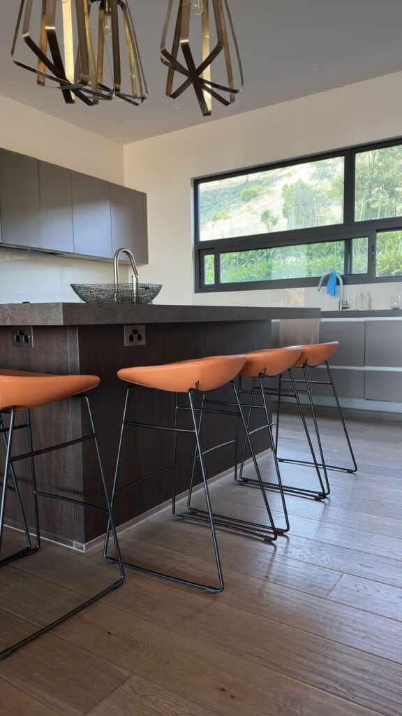 Detail view of tan Voyager Interiors bar stools with black frames