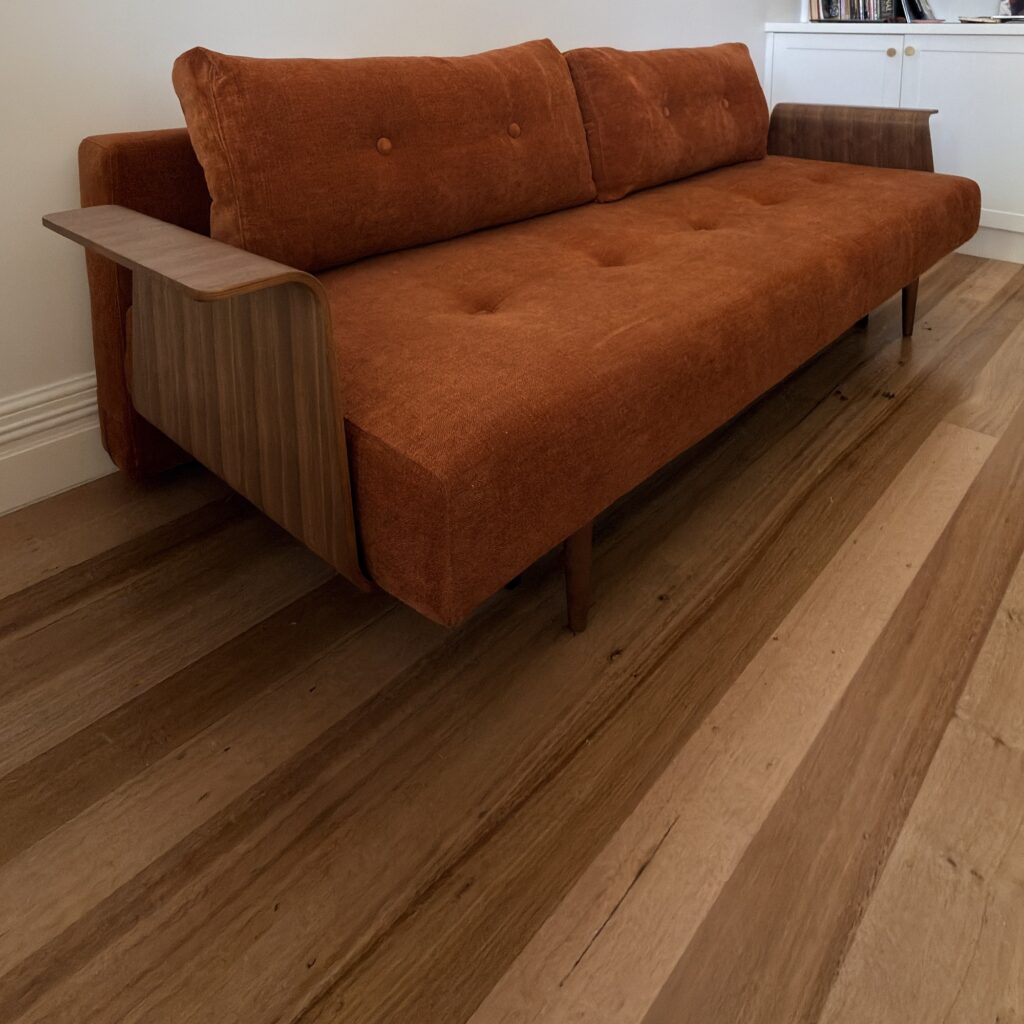 Angled view of a rust-coloured Innovation Living Recast sofa bed delivered to a Coburg home.